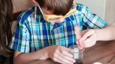 Kimya deneyleri evde. Anne ve oğlu gaz kimyasal bir reaksiyon sürümü ile test tüpü içinde olun.