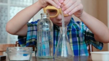 Kimya deneyleri evde. Çocuk su şişe bir pipet kullanarak balonun dökülen..