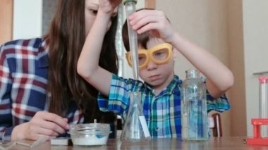 Kimya deneyleri evde. Çocuk su şişe büyük bir pipet kullanarak balonun dökülen..