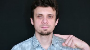 Sakal, anız, siyah arka plan üzerine temiz traşlı adam. Esmer hafif ekose gömlekli. Önden Görünüm.