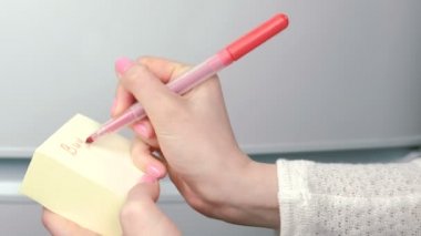 Kadının eller üzerine sarı etiket kağıt yaprak kelime satın yazmak: süt, ekmek, tavuk. Aile Not