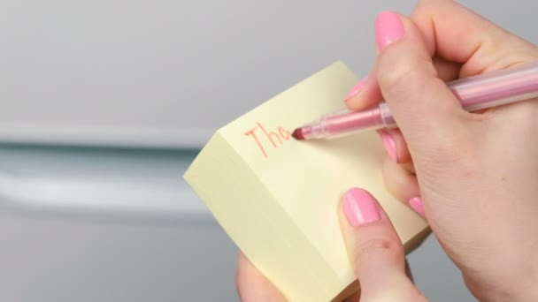 Närbild kvinnans händer skriver på gult klistermärke papper ark ord Tack för bästa natten nånsin. — Stockvideo