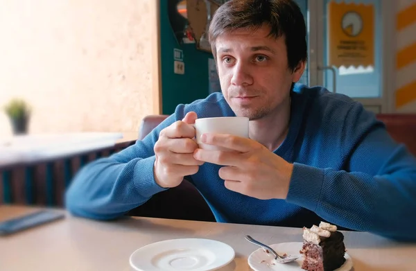 Jonge man drinken een kopje thee in café. — Stockfoto