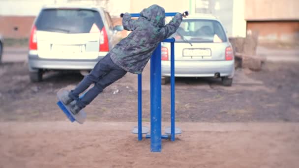 Junge macht Übungen im Simulator auf der Straße. — Stockvideo