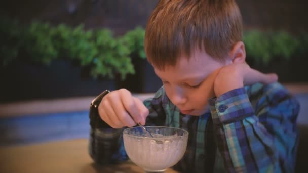 Garçon mange de la crème glacée et regarde la télévision . — Video