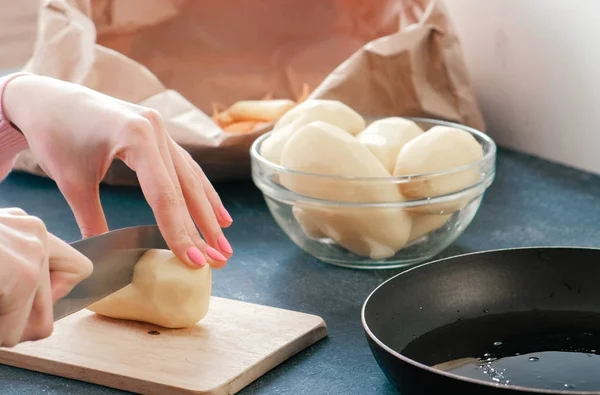 Крупным планом женские руки режут картошку на деревянной доске . — стоковое фото