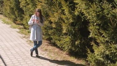 Navigasyon haritası şehrin yolunu bulmak için telefonunuzdaki montlu genç esmer kadın bakar.
