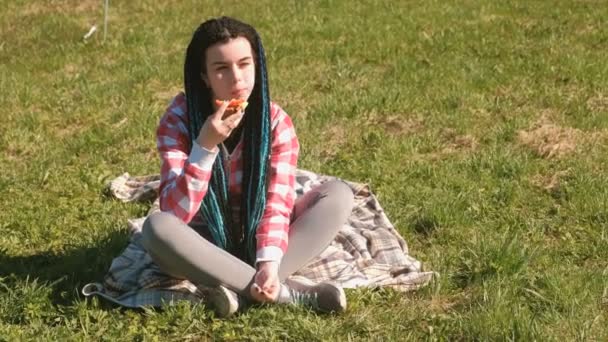 Joven morena come sándwich en el picnic en el parque . — Vídeos de Stock