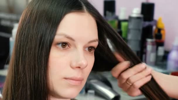 Fodrász alkalmazzák a gondozás a nők hosszú haj balzsam. Vértes ügyfelek arc. — Stock videók