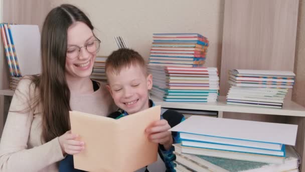 Moeder en zoon Lees een boek samen. Moeder in glazen. — Stockvideo