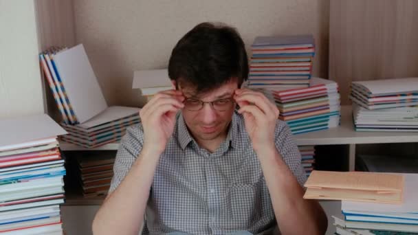 Молодий щасливий брюнетка людина одягає окуляри і читає книгу . — стокове відео