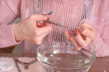 Kadın manikür makas ile keser. Yapar kendini manikür. Yakın çekim yakışıklı.