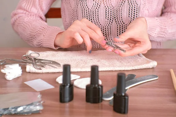 Kvinna skar sina naglar med clippers. Närbild händer. Spik lack fokus. — Stockfoto