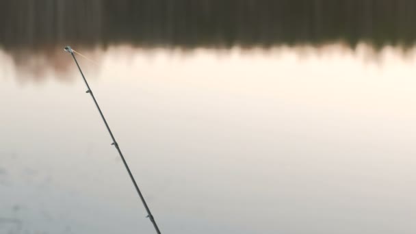 Fishing rod on the river Bank. Fishing at sunset on a spring evening. — Stock Video