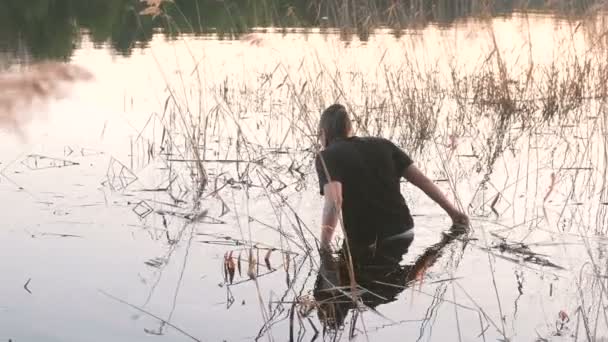 Pescador buscando un aparejo empotrado en el agua del río . — Vídeo de stock