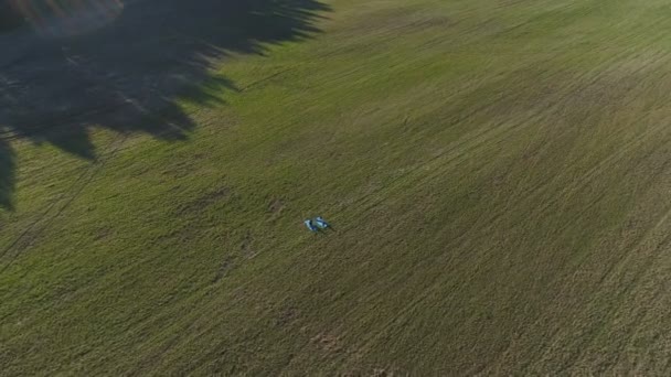 Дві дівчини тягнуться на килимки на полі. Панорамний вид з повітря . — стокове відео