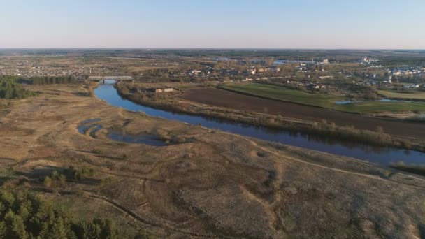 Lot nad zielone pola, Las, rzeka i wieś wczesną wiosną, panoramiczny widok z lotu ptaka. — Wideo stockowe