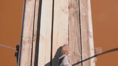 Adam ahşap Asma köprüde Nehri üzerinde yürüyor. Yakın çekim bacaklar.