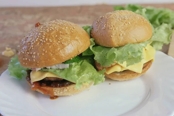 İki farklı ev yapımı hamburger beyaz plaka üzerinde