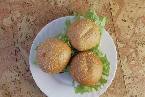 Üç ev yapımı hamburger beyaz tabakta. Üstten Görünüm. — Stok fotoğraf