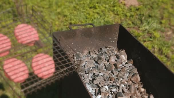 La mujer pone una parrilla con chuletas en el brasero. Mano de primer plano . — Vídeo de stock