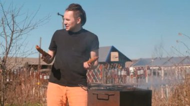 Erkek ve kadın genç çift pirzola Kavurma ve hamburger ızgara ekmek. Kapalı aile günü