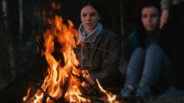 İki kadın ve çocuk ateşin önünde bir yaz akşamı bak. Aile tatil hafta sonu.