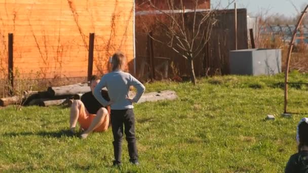 Papás jugando con su hijo y su hija en el patio trasero . — Vídeo de stock