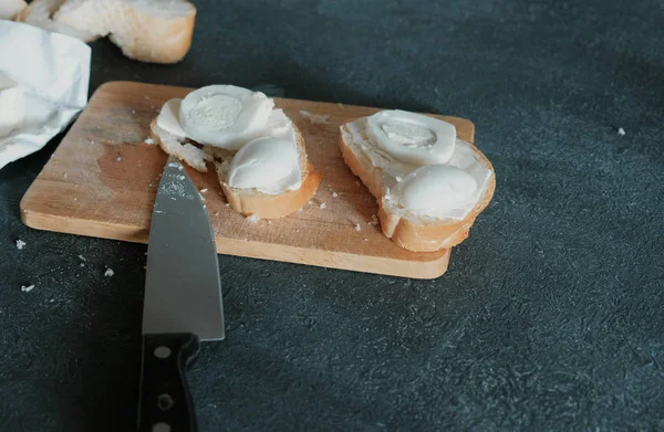 Ekmek, tereyağı ve yumurta ahşap tahta siyah arka plan üzerinde closeup sandviç. Bir sandviç yapmak.