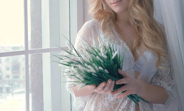 젊은 슬림 섹시 한 금발 소녀 란제리에 내실 창턱에 lookingin 그녀의 손에 있는 인공 꽃에 앉아. 근접 촬영 바디. — 스톡 사진