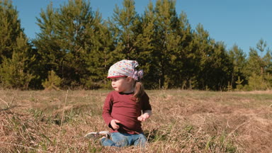 Orman çim oturan kız ve erkek kardeşim oynamak.