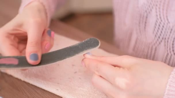 Vrouw poetsmiddelen haar nagels met nagelvijl vóór verwijderen schellak. Close-up van de handen. — Stockvideo