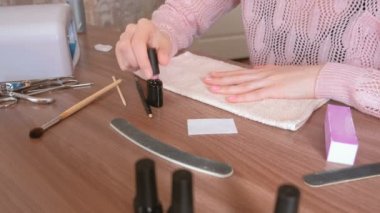 Kadın pembe gomalak ilk kat tırnakları koyar. Yakın çekim.