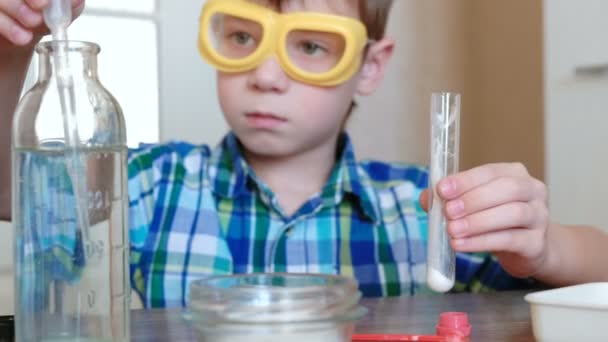 Experimentos de química en casa. Boy vierte el agua en el tubo de ensayo con polvo usando pipeta . — Vídeo de stock