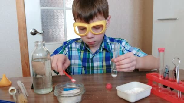 Experimentos de química en casa. Reacción química con la liberación de gas en un tubo de ensayo en las manos de un niño sorprendido . — Vídeo de stock