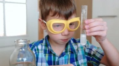 Evde kimya üzerinde deneyler. Sürpriz bir çocuk elinde bir tüp gaz kimyasal reaksiyon ile belgili tanımlık serbest bırakmak. Portre.