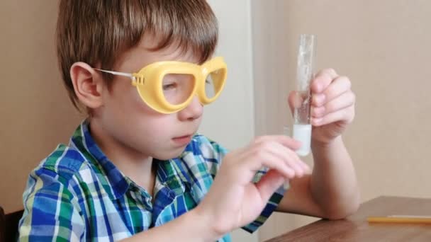 Experiências de química em casa. Menino bate em um tubo de ensaio com reagentes usando vara de vidro . — Vídeo de Stock