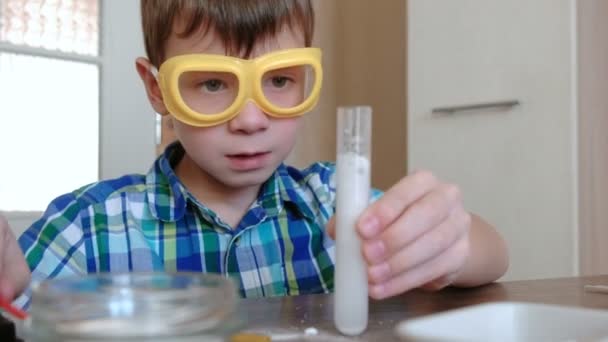 Experimente zur Chemie zu Hause. überraschten Jungen Gesicht beim Betrachten der chemischen Reaktion mit der Freisetzung von Gas im Reagenzglas in seinen Händen. — Stockvideo