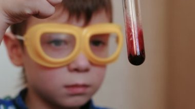 Evde kimya üzerinde deneyler. Tatlı çocuklar yüz test tüpü içeriğini denetler.