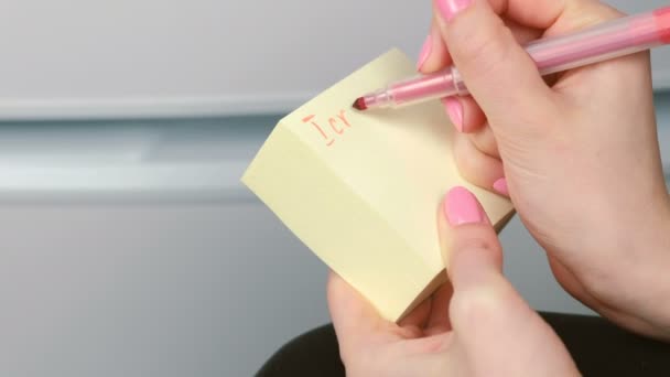 Крупный план женщины руки написать на желтой наклейке бумажных листов слова я разбил вашу машину, извините . — стоковое видео