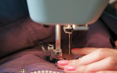 Seamstressess eller Close-Up diker için mavi ceket deri dikiş makinesi üzerinde ekler. Yan görünüm.