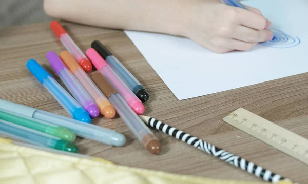 Primo piano delle lancette dei bambini disegnare ovali con un pennarello blu su carta bianca — Foto Stock