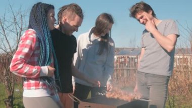 Grup Genç insanlar arkadaşlar Barbekü şaşlık et arka bahçesinde üzerinde kömür ızgara üzerine. Konuşmak ve birlikte gülümseyen.