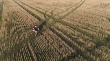 Kırsal kesimde bir dinlenme yaşamalı. Genç alan sandalyede oturan adam ve telefon ile arayabilirsiniz. Havadan panoramik görünümü.