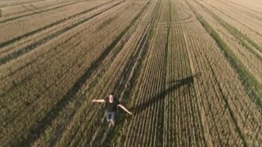 Uzanmış silah sahada koşan genç başarılı mutlu adam. Havadan panoramik görünümü.