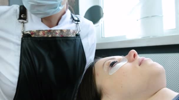 Лікування краси. Косметолог наносить чорну фарбу на вії. ламінування вій . — стокове відео