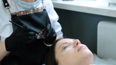 Güzellik bakımı. Güzellik uzmanı siyah boya kirpiklere üzerinde koyar. kirpik laminasyon.