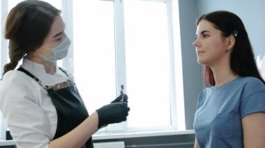 Güzellik uzmanı cımbız ile düzeltme kaş yordam gerçekleştirir. Yan görünüm.