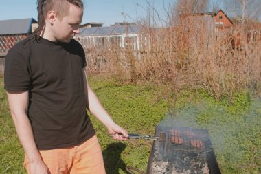 Genç adam ızgarada biftek pirzola kavurma.