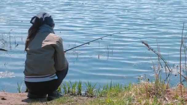 一个温暖的春天在池塘钓鱼的妇女. — 图库视频影像